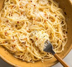 a bowl filled with pasta and topped with parmesan cheese