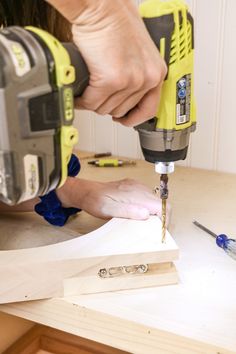 a person using a drill to cut wood