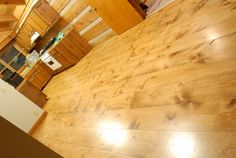 an empty room with wood floors and cabinets