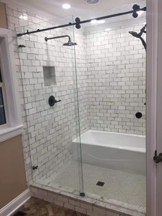 a white bath tub sitting inside of a bathroom next to a walk in shower stall