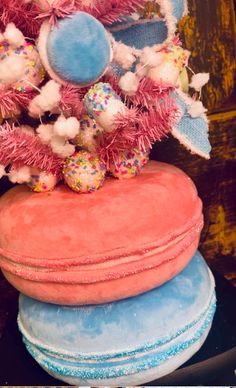 three round cushions stacked on top of each other in front of a wooden wall with pink, blue and white decorations