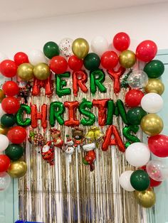 a merry christmas balloon arch with balloons and streamers