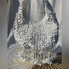 This Darling White Flower Purse Is A Perfect Entrance Into The Spring! Perfect For Your Next Vacation Or Night Out. Delicate And Charming, One Of A Kind, It Is Entirely Covered With Dimensional White Flowers. The Beaded And Flowerette Tassels Take This Design To The Next Level With Its Fun Girly Charm. Its Truly So Well Made And Designed. Spacious Bag Will Hold A Cell Phone, Wallet And Make Up For Touch Ups. Size: From Top Of Strap To Bottom Of Bag 10in Zipper To Bottom Of Bag 5.5in Across 8.5in Handmade White Evening Shoulder Bag, Elegant White Handheld Hobo Bag, Elegant White Evening Hobo Bag, White Spring Bag With Pearl Handle, White Spring Bags With Pearl Handle, Spring White Bag With Pearl Handle, Summer White Pouch Hobo Bag, White Tote Shoulder Bag For Wedding, White Bucket Bag For Wedding