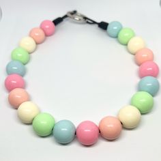 a multicolored beaded necklace on a white surface