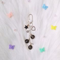 a keychain with two charms attached to it sitting on a white fur surface