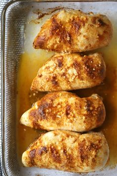 three pieces of chicken sitting on top of a pan filled with oil and seasoning