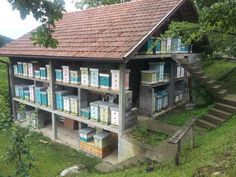 an old building with lots of bee boxes on the roof and stairs leading up to it