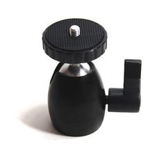 a small black coffee pot on a white surface with a cup holder attached to it