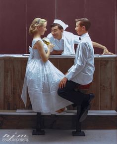 a man in a sailor's hat is sitting on a bench with two women