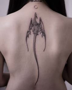 a woman's back with a dragon tattoo on it