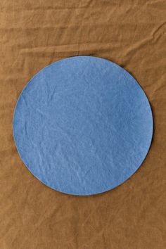 a blue circle on brown paper sitting on top of a table