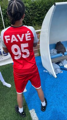 a young boy is standing in front of a fake football goalie's bed