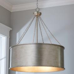 a chandelier hanging from the ceiling in a room with white walls and windows