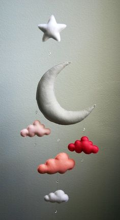 a mobile made to look like the moon and stars are floating in the sky with clouds