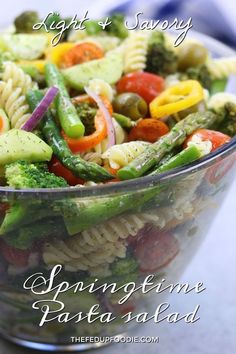 a glass bowl filled with pasta and vegetables