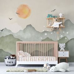 a baby's room with mountains and birds painted on the wall, including a crib