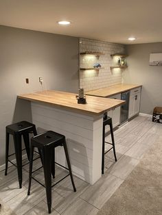 a kitchen with two bar stools next to it