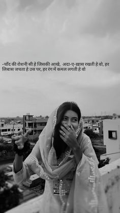 a woman is standing on the roof with her hands up to her mouth and looking at the camera