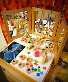 a mirror that is sitting on top of a table with beads and other items in it