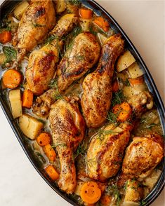 chicken, potatoes and carrots in a pan on a table