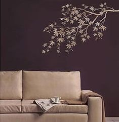 a living room with a couch, coffee table and wall decal on the wall