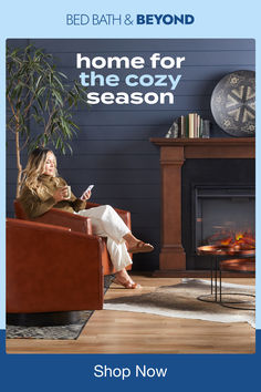 a woman sitting on a chair in front of a fireplace with the caption home for the cozy season shop now