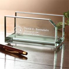 a pen sitting on top of a desk next to a glass block with the name david c bernstin