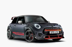 the front end of a grey mini cooper hatchback car with red stripes on it