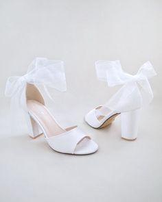 a pair of white shoes with bows on them