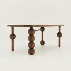 a wooden table with three balls on it's legs and one leg extended to the side