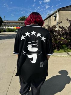 Counting Stars ⭐️⭐️⭐️⭐️⭐️ Stray Kids 5-Star themed black jersey. S-Class who? This black jersey is centered around the 5 Star album cover with Stray Kids logo on the sleeve. Perfect for concerts, street outfit, or learning choreo. * Logo on the sleeve is optional. Please leave a note as a personalization if you do not want it. ** Do you have a bias? Don't be shy leave a note! 🤭  If you don't or if this is a gift and you don't know it's okay this does not affect production. Casual Black T-shirt With Star Print, Black Letter Print Baseball Jersey For College, College Black Baseball Jersey With Letter Print, Black College Baseball Jersey With Letter Print, Black Short Sleeve Baseball Jersey For College, Black Short Sleeve College Baseball Jersey, Black Baseball Jersey With Graphic Print For Sports Season, Urban Black T-shirt For Sports Events, Sporty Black Baseball Jersey With Graphic Print