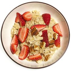 a bowl filled with oatmeal, strawberries and pecans