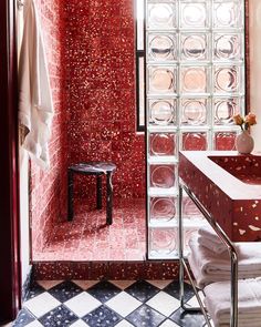 the bathroom is decorated in red and white with lots of glass blocks on the wall