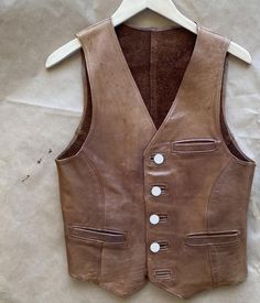 Brown leather vest, snap button closure, biker, motorcycle, western, cowgirl style, genuine leather Women's Tan and Brown Gilet *return policy* We do not compromise on quality and comfort. Return and Refund Policy: This item includes a 100% Money Back Guarantee! If you are not completely satisfied with your purchase for any reason, you received damaged, faulty product or you did not receive the size that you originally ordered, just send it back to our return address and we will issue you a refu Brown Gilet, Brown Leather Vest, Western Cowgirl Style, Vintage Leather Vest, Custom Jacket, Western Cowgirl, Vest Outfits, Leather Vest, Cowgirl Style