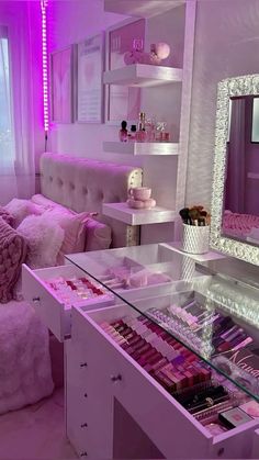 a room filled with lots of pink and white furniture next to a large mirror on the wall