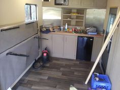 the inside of a small kitchen that is being remodeled with wood flooring and stainless steel appliances