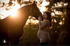 a pregnant woman standing next to a brown horse at sunset with the sun behind her