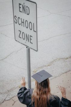 a girl in graduation cap and gown holding up a sign that says end school zone