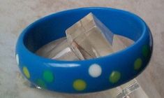 Teresa created this beautiful Confetti Dotted Bakelite bangle bracelet. It features distinctly different sizes and colors of Dots, she used a bright blue bracelet and decorated with multiple inlaid confetti multi-colored dots. I am including photos of how these bracelets looked when they were first created and how they have aged to a beautiful vintage green and orange. The Photos tell the story. This bracelet was made for me about 17 years ago so the vintage patina is returning to the piece. Sig Unique Handmade Blue Bangle, Unique Blue Bangle Cuff Bracelet, Unique Blue Bangle, Adjustable Round Blue Bangle, Unique Adjustable Blue Bangle, Bakelite Bangles, Confetti Dots, Blue Bracelet, Deep Green