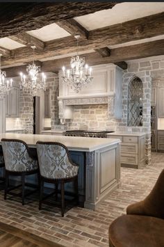 a large kitchen with an island and chandelier hanging from it's ceiling