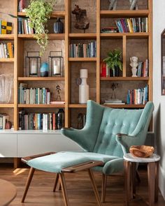 a living room filled with furniture and bookshelves next to a wall full of shelves