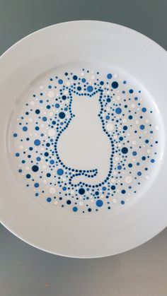 a white plate with blue and white dots in the shape of a cat on it