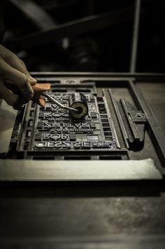 a person is using a combination lock on a metal device that has been placed in a machine