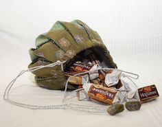 a bag filled with chocolates sitting on top of a white bed next to a chain