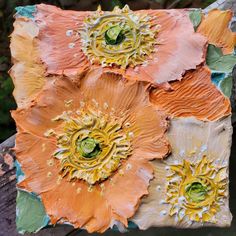 an orange and yellow flower is painted on a piece of wood