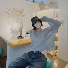 a woman wearing a face mask while sitting on a chair in front of a table