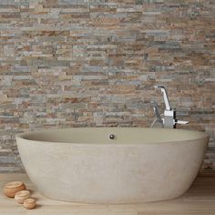 a stone bathtub sitting on top of a wooden floor next to a faucet