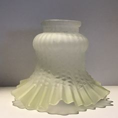 a white glass vase sitting on top of a table