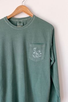 The earth laughs in flowers 🌸 Channel your inner florist! This is a simple, wildflower design perfect for a day on the town, or a weekend away! Pair this top with your favorite pair of shorts, or a flirty twirl skirt! Embroidered on your choice of a Comfort Colors light green pocket tee, pocket long sleeve, or crewneck sweatshirt. Embroidered Pocket Tees, Casual Embroidered Organic Cotton Tops, Casual Long Sleeve T-shirt With Floral Embroidery, Green Cotton Top With Floral Embroidery, Organic Cotton Long Sleeve T-shirt For Spring, Spring Embroidered Top For Everyday Wear, Embroidered Tops For Everyday Spring Wear, Casual Cotton Tops With Floral Embroidery, Casual Embroidered Tops For Everyday