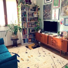 a living room filled with furniture and a flat screen tv sitting on top of a wooden cabinet